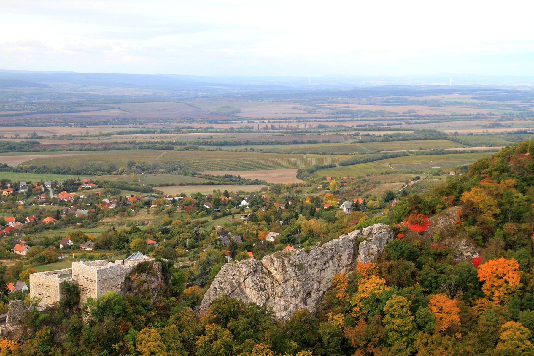 Őszi panoráma várromal és sziklákkal, a háttérben a síkság